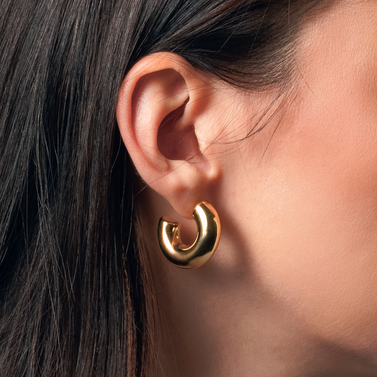 Pendientes Maca Gold de aro grueso en baño de oro usados en modelo, ideales para looks llamativos y sofisticados.