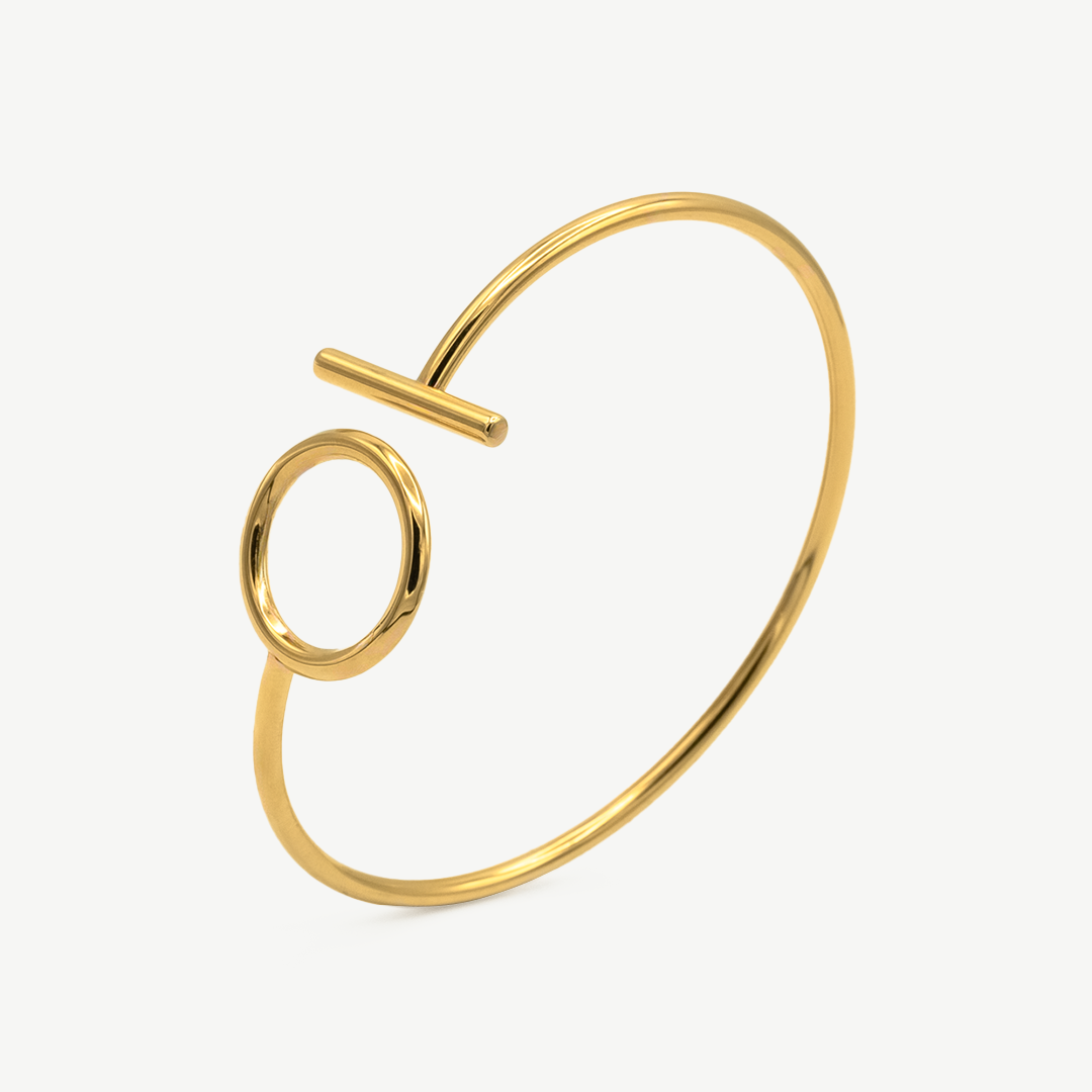 Pulsera Nébula Gold con cierre geométrico en forma de círculo y barra bañada en oro, diseño minimalista de Manía de Manía.